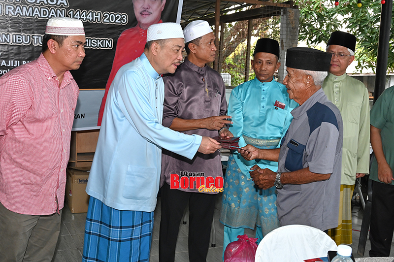  Hajiji (dua kiri) menyampaikan sumbangan kepada seorang penerima pada majlis berkenaan.