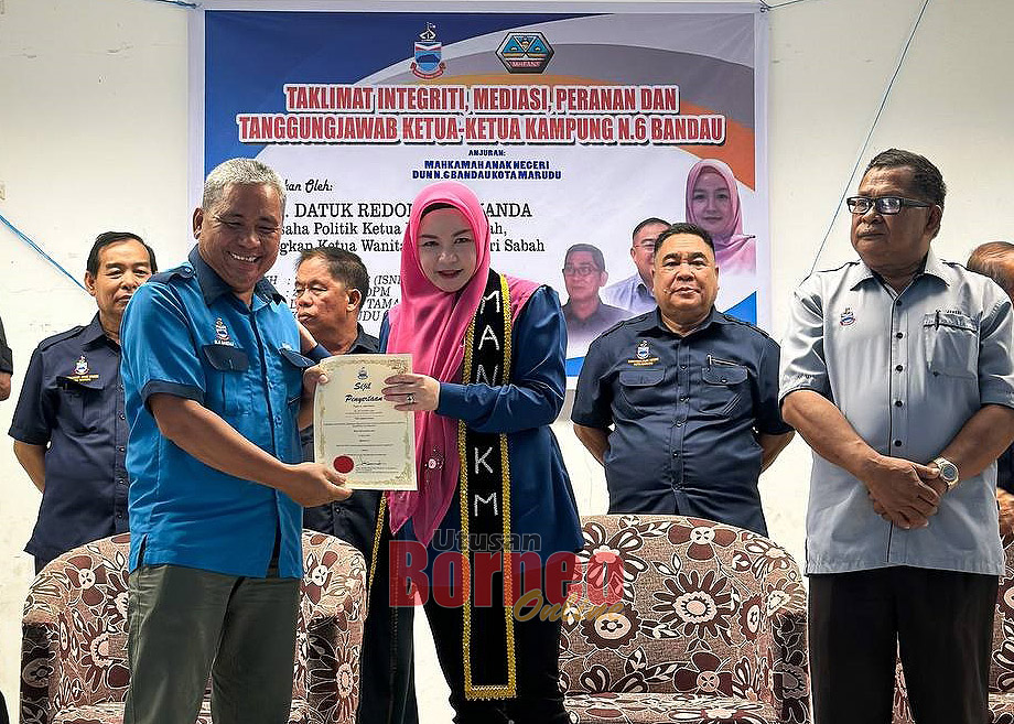  Redonah menyampaikan watikah pelantikan kepada salah seorang Ketua Kampung di Bandau, Kota Marudu.