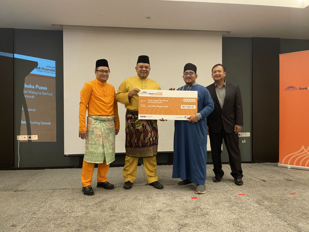 Khairul (dua kiri) menyampaikan sumbangan kepada wakil dari Pusat Jagaan Nur Murni. Turut kelihatan, Zainal Pattate (kiri) dan Pele Peter Tinggom.