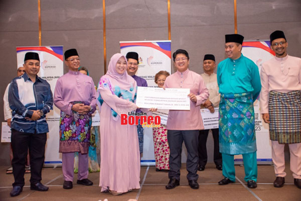  Ewon (tiga kanan) menyampaikan replika cek sumbangan IKMa kepada wakil Pertubuhan Kadazan Dusun Murut Muslim Semalaysia (KDMMS Muslim) pada majlis itu. Turut kelihatan Mohd Ali (dua kanan).