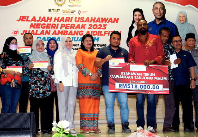 Saraswathy (tengah) bergambar bersama para penerima bantuan Usahawan Tekun pada majlis Perasmian Jelajah Hari Usahawan Negeri Perak 2023 @ Jualan Ambang Aidilfitri Daerah Muallim di Majlis Daerah Tanjong Malim hari ini. - Gambar Bernama 