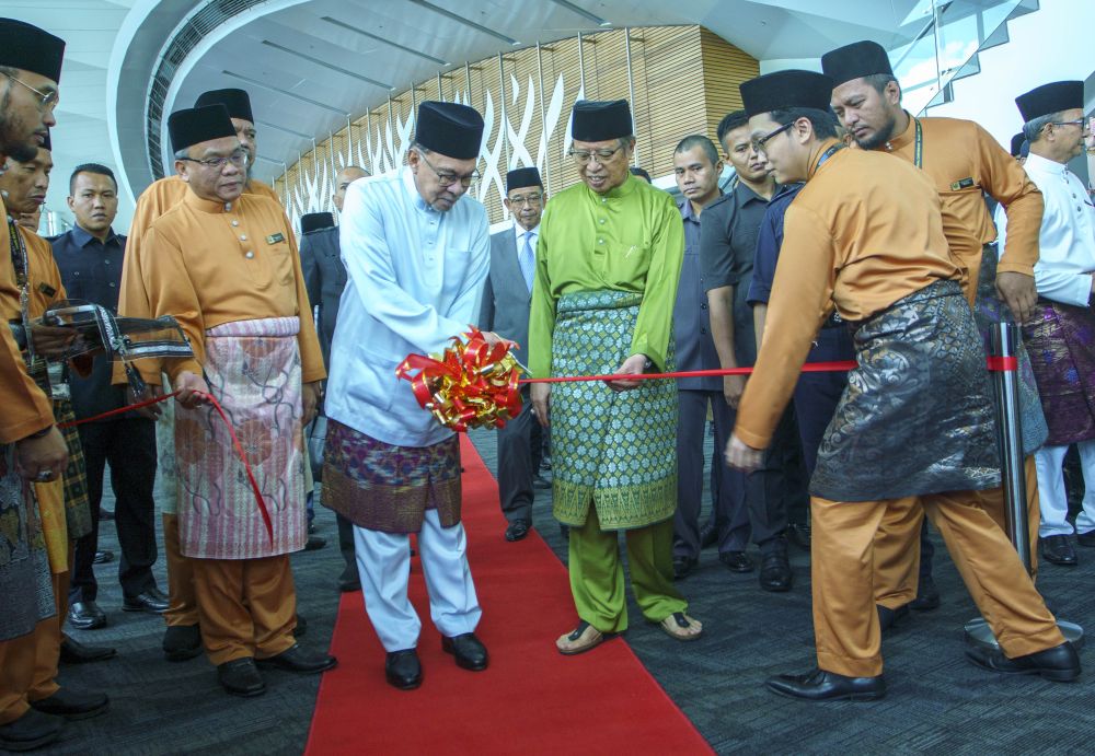 Abang Johari mengiringi Anwar merasmikan pameran yang diadakan Seminar Antarabangsa Imam As-Syafi'i di BCCK, hari ini. - Gambar Muhammad Rais Sanusi