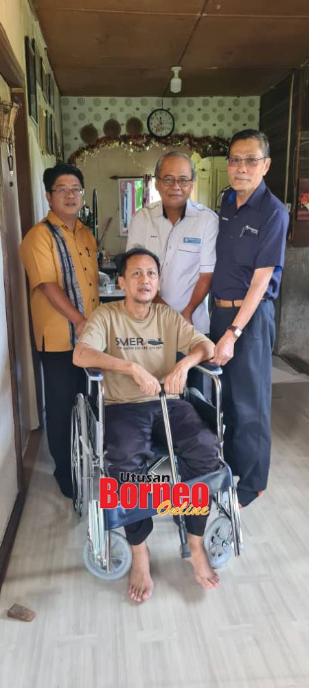  Ewon (kiri), Philip (tengah) merakamkan gambar kenangan bersama seorang penerima kerusi roda.