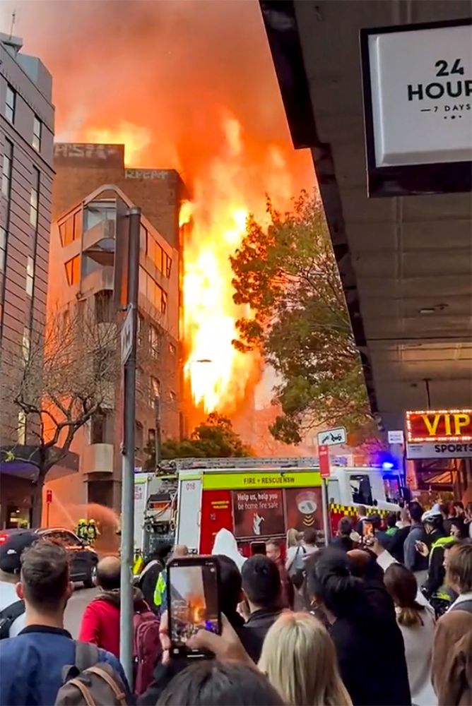 Imej diambil daripada video UGC dan dipaparkan oleh Grant Ozolins di akaun Twitter @grantozolins kelmarin menunjukkan orang ramai menyaksikan kebakaran sebuah bangunan tujuh tingkat di tengah Sydney. — Gambar AFP  