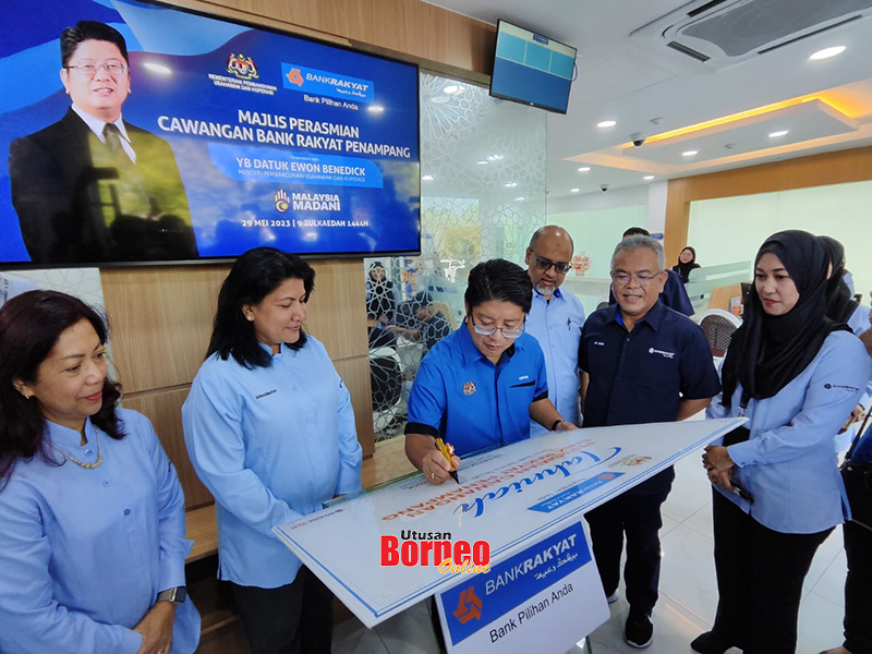  Ewon (tengah) menyempurnakan simbolik perasmian cawangan Bank Rakyat Penampang.