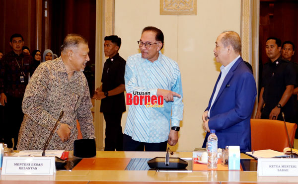  Anwar (tengah) menyambut Hajiji (kanan) dan Menteri Besar Kelantan Datuk Ahmad Yaakob (kiri) di pejabatnya di Putrajaya.