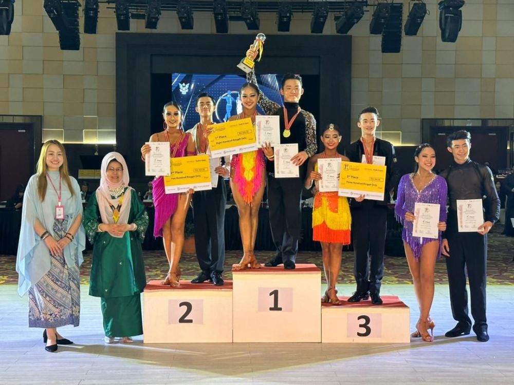 Fatimah menyampaikan hadiah kepada juara bagi ‘Youth A Open Latin Category’ untuk pasangan Ooi Ken Vin dan Zoe Tan Zi Wei pada majlis Makan Malam BOIDC di Kuching, malam Ahad.