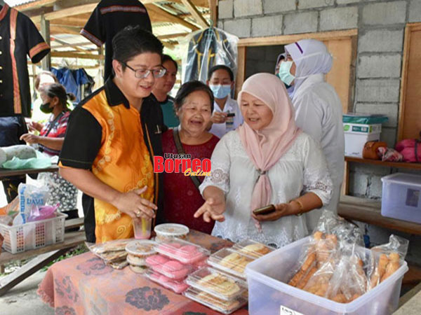  Ewon (kiri) sempat meninjau produk jualan peniaga wanita di Tamu Pongindopuan Kampung Rangalau Kota Belud.