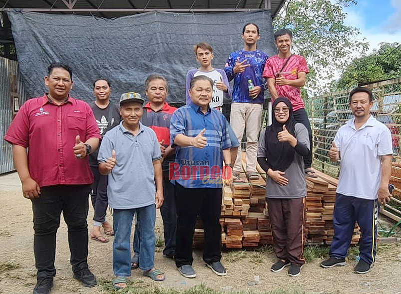  Robert (tiga kanan) semasa menyerahkan sumbangan beruti dan papan kepada pengurusan JPKK Kg Baginda Ulu yang diterima oleh Sumiati (dua kanan) dan Julius.