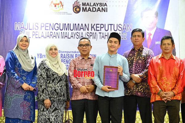  Zaini (tiga kiri) merakamkan kenangan bersama Arief Syafiq (tiga kanan) selepas menerima sijil penghargaan pelajar cemerlang SPM 2022.