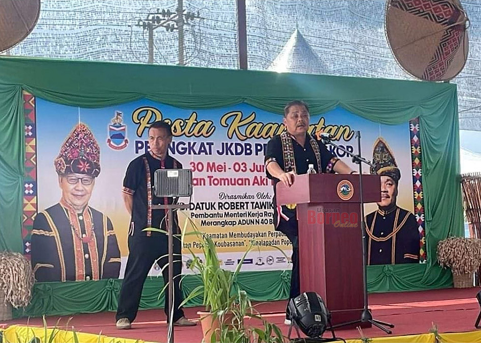  Robert (kanan) ketika menyampaikan ucapan bagi merasmikan sambutan Pesta Kaamatan JKDB Pekan Bingkor di Dewan Tamuon Aki Tingadon Pantayan.