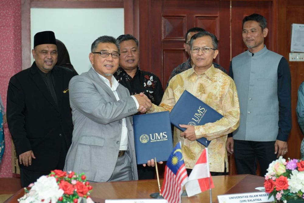  Kasim (kiri) bertukar dokumen LoI bersama Zakiyuddin menandatangani LoI di Bangunan Canselori UMS di sini.