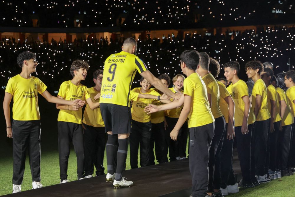 Benzema disambut oleh kanak-kanak semasa memasuki padang dalam upacara pengenalannya di Stadium Al-Ittihad di Jeddah. — Gambar AFP