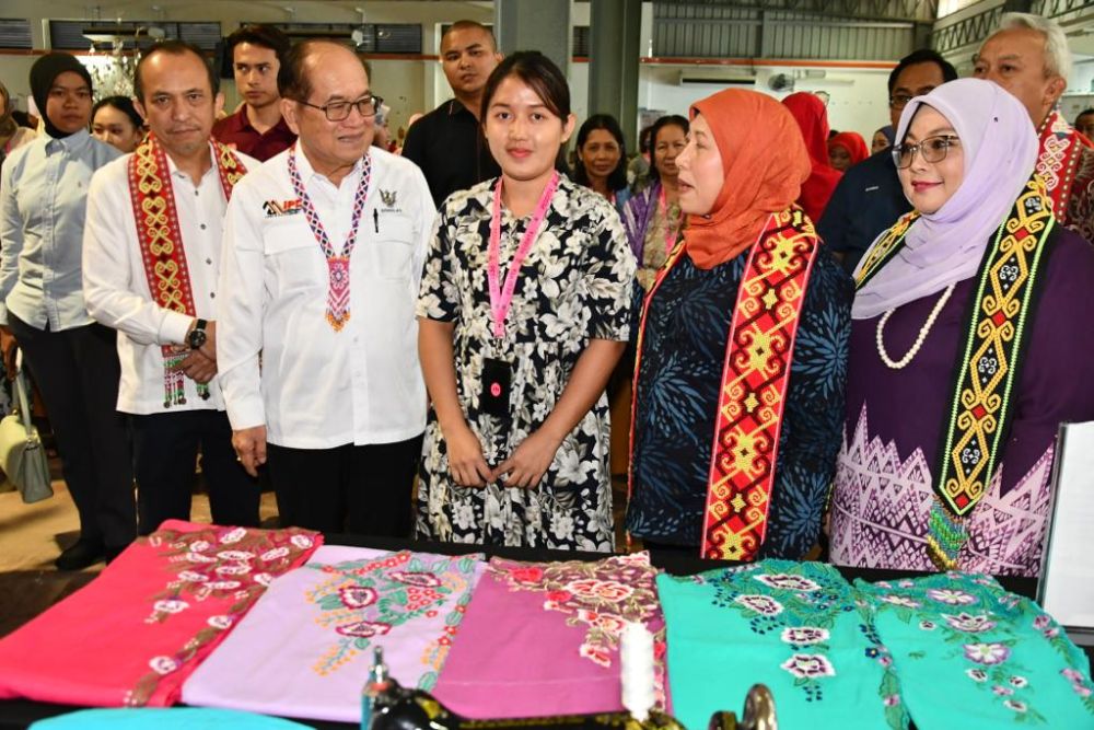(dari kiri depan) Dr Richard, Uggah dan Nancy di pameran mini pakaian kebaya yang dihasilkan oleh Kristyna Soekarno (tengah), seorang tukang jahit cacat pertuturan.