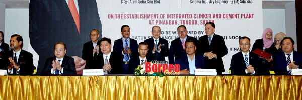  Hajiji (berdiri tengah) bersama tetamu jemputan lain menyaksikan majlis menandatangani perjanjian usahasama di antara wakil SEDCO, Sri Alam Setia Sdn Bhd, Borneo Cement (Sabah) Sdn Bhd, dan Sinoma Industrial Engineering (M) Sdn Bhd.