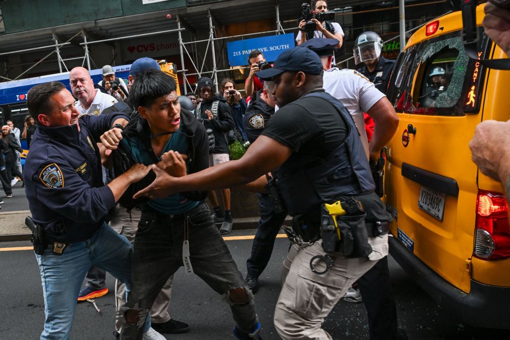 Anggota polis menangkap seorang lelaki ketika acara pemberian konsol permainan PlayStation5 di New York kelmarin bertukar menjadi huru-hara. — Gambar AFP