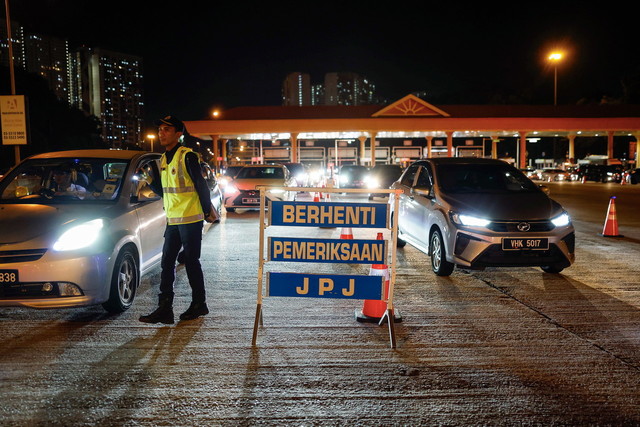 Anggota JPJ mengadakan sekatan jalan pada Operasi Bersepadu di Plaza Tol Awan Besar (Timur), malam tadi. -Gambar BERNAMA