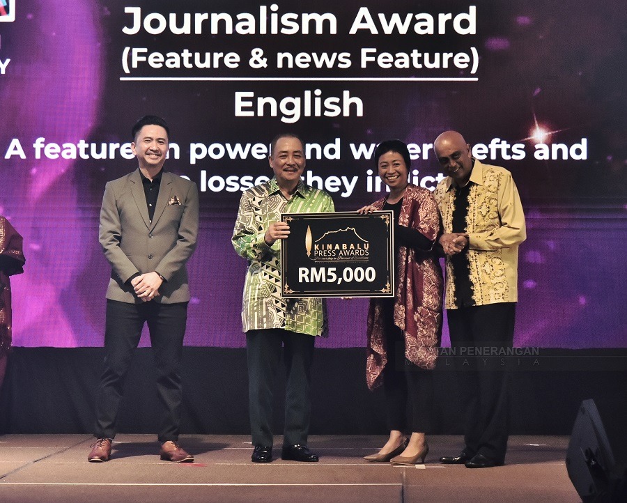  Hajiji ketika  menyampaikan anugerah kemenangan kepada  seorang pemenang anugerah utama sempena Kinabalu Press Awards 2023 di sini pada Sabtu.