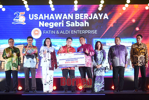  Ewon (tengah) menyampaikan Anugerah Usahawan Berjaya TEKUN Sabah kepada Samsu Alam Idrus.