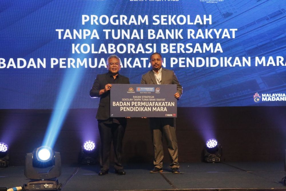 Mohammad Hanis (kiri) dan Presiden Badan Permuafakatan Pendidikan MARA Malaysia Dato Sayed Alfeizal Syed Ahmad (kanan) semasa Majlis Jalinan Kolaboratif Bank Rakyat dan Rakan Strategik bagi Program Sekolah Tanpa Tunai di Menara Kembar Bank Rakyat.