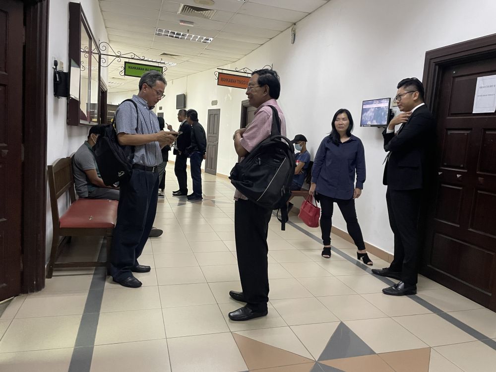 Kedua-dua wakil syarikat dan pengarah Sentoria Borneo Land Sdn Bhd bersama peguam mereka Wong (kanan) semasa berada di hadapan kamar Mahkamah Majistret pada Khamis.