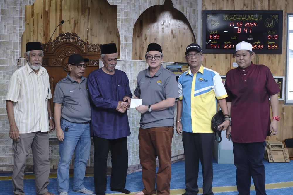  Pengerusi PMBS Tanjung Aru, Pg Alliyuddin (tiga kanan) menyampaikan bantuan kepada Ekah.