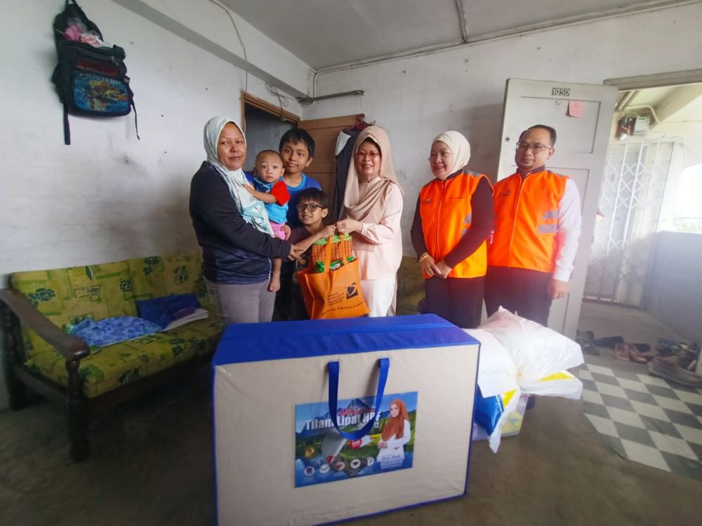 Fatimah (tiga kanan) menyampaikan sumbangan kepada Patimah (kiri) dan keluarganya di kediaman mereka di Flat KMC hari ini.