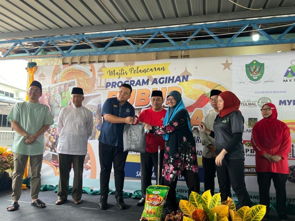 Hilmy menyampaikan sumbangan bakul makanan kepada golongan asnaf pada Program Agihan Bubur Pedas KJM Samariang di Surau Darul Falah, Samariang Baru Fasa 3 hari ini.