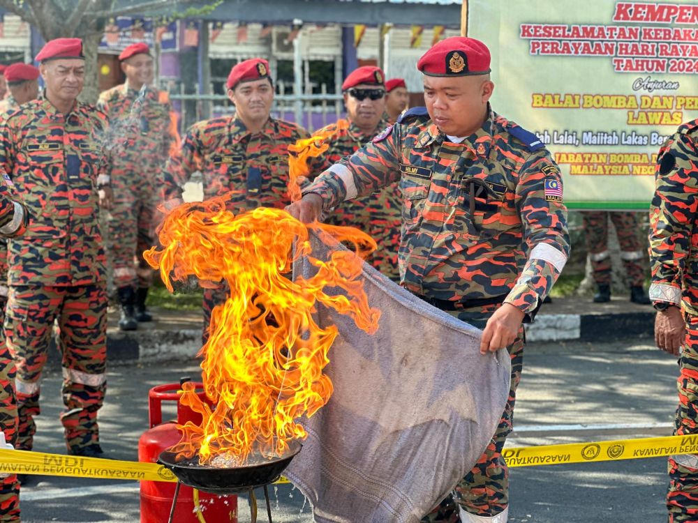 Seorang anggota bomba menunjukkan cara memadam api pada Kempen Keselamatan Kebakaran Musim Perayaan Hari Raya Aidilfitri 2024 di Lawas.