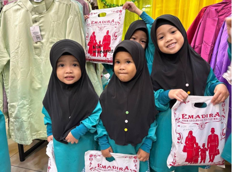  Kanak-kanak gembira menerima pakaian raya daripada Emadira.