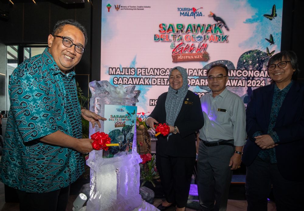 Mohd Roslan melakukan gimik pelancaran Pakej Pelancongan Sarawak Delta Geopark dan Gawai 2024 sambil disaksikan yang lain di Hotel Roxy Impiana hari ini. -Gambar Chimon Upon
