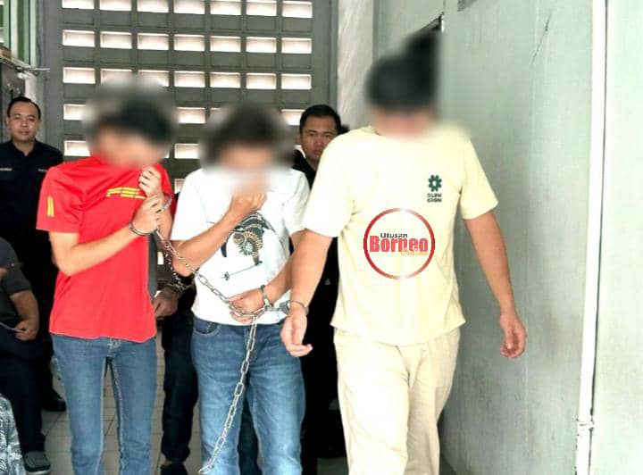 Anggota polis membawa dua daripada suspek (kanan dan tengah) keluar dari bilik mahkamah di Sibu semalam.