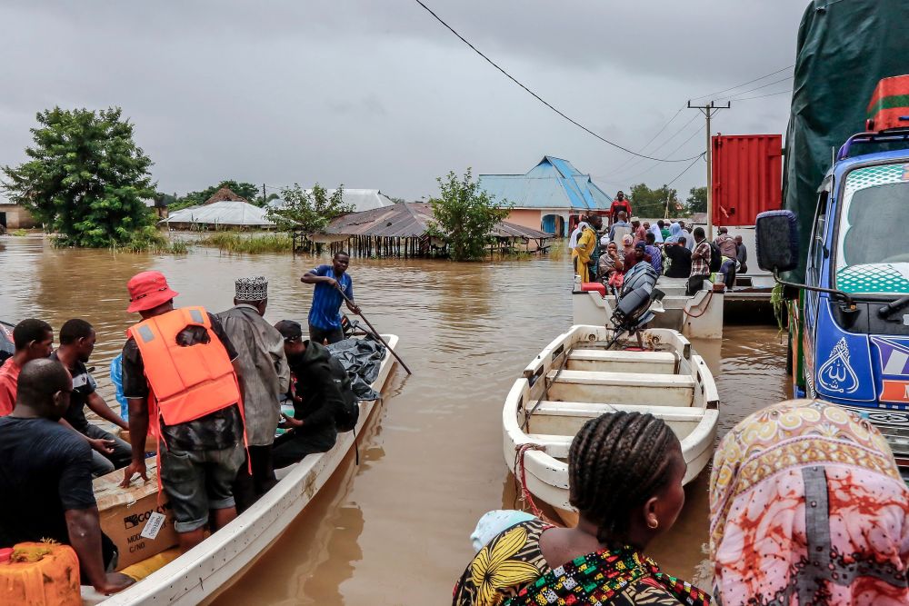 Penduduk dipindahkan dengan menaiki bot dari kawasan terjejas teruk akibat banjir selepas hujan lebat di kampung Mohoro, Daerah Rufiji baru-baru ini. — Gambar AFP