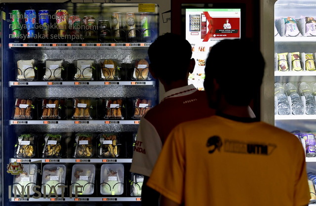 Para pelajar UiTM beratur untuk membeli makanan melalui mesin layan diri IPR yang diletakan di Kolej Angsana 2 UiTM Cawangan Selangor Kampus Puncak Alam baru-baru ini. - Gambar BERNAMA