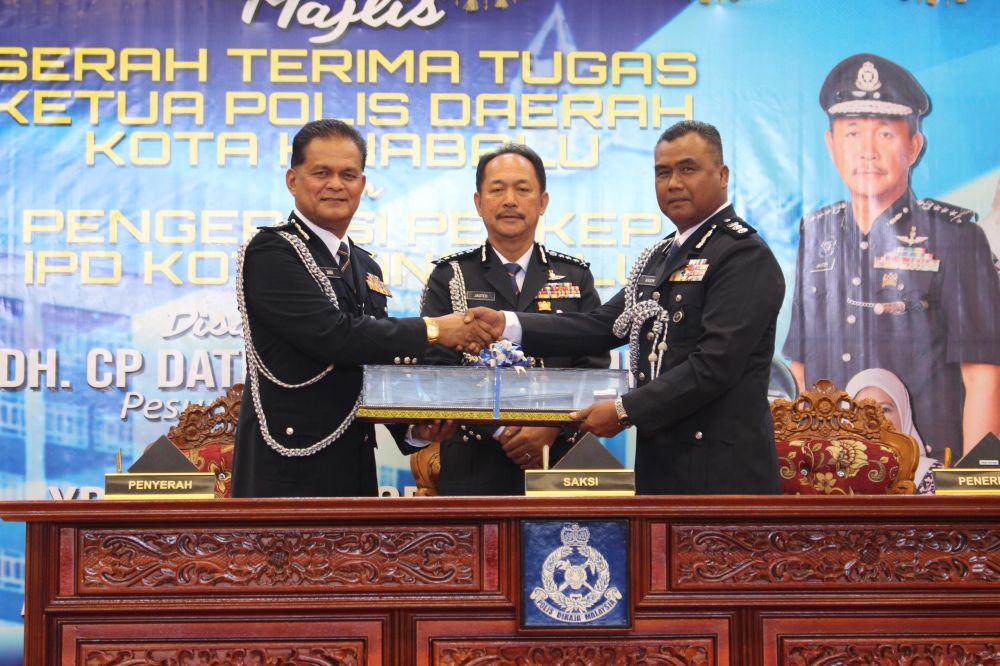  Jauteh menyaksikan Mohd Zaidi menyerahkan tongkat kuasa kepada Kasim sebagai simbolik penyerahan tugas Ketua Polis Daerah Kota Kinabalu.