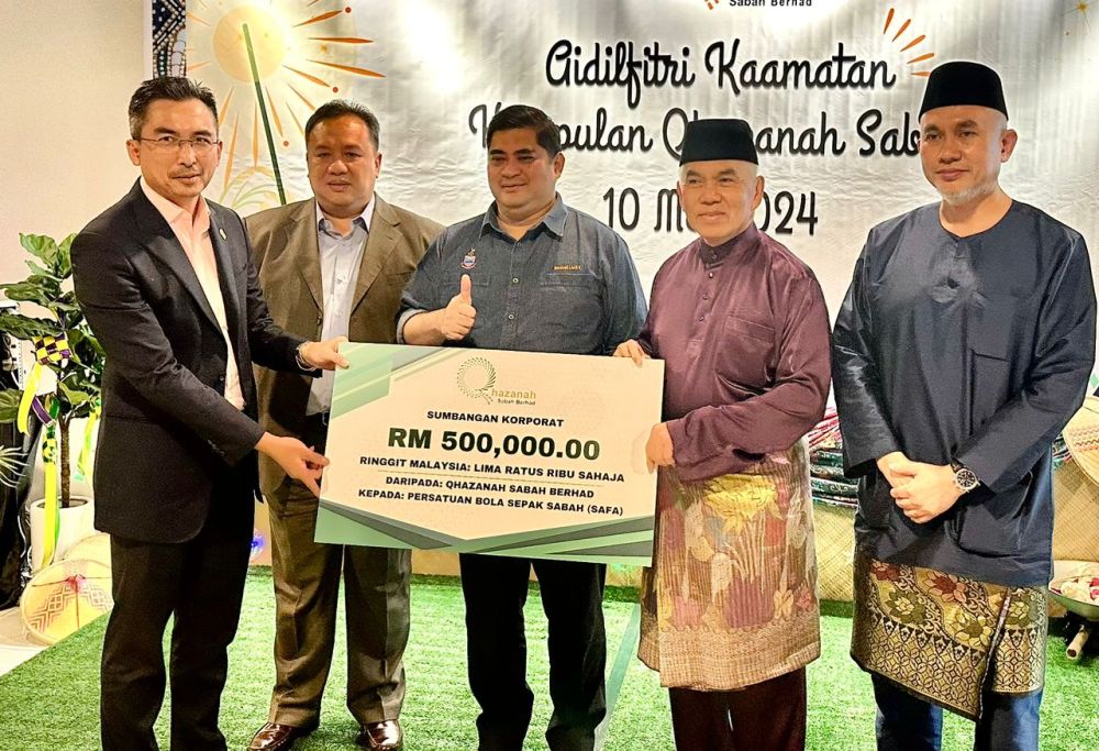  Yusof (kanan) menyampaikan replika cek RM500,000 kepada Mohd Joh.