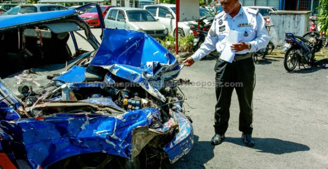 TRAGIS: Anggota polis trafik membuat pemeriksaan terhadap kenderaan yang terlibat dalam kemalangan maut melibatkan empat mangsa awal pagi semalam di Jalan Kota Bharu-Machang-Jeli di Ibu pejabat Polis Daerah Tanah Merah. — Gambar Bernama