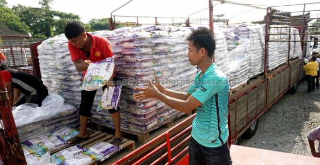 AGIH: Dua kelindan lori mengalihkan beras fidyah ke dalam lori sebelum diagihkan kepada penerima di seluruh negeri Kedah pada majlis Penyerahan Beras Fidyah 2017, di Pejabat Lembaga Zakat Negeri Kedah semalam. — Gambar Bernama 