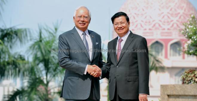 SELAMAT DATANG: Najib bersalaman dengan Dr Thongloun (kanan) ketika sambutan rasmi di pekarangan Bangunan Perdana Putra di Putrajaya, semalam. — Gambar Bernama