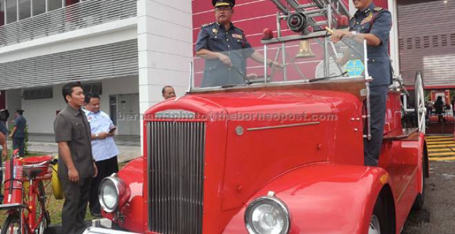 LAWATAN: Noh Omar diiringi Ketua Pengarah Jabatan Bomba dan Penyelamat Datuk Wira Wan Mohd Nor Ibrahim menaiki jentera bomba Dennis T974 ketika melawat ruang pameran selepas merasmikan Balai Bomba dan Penyelamat Ayer Hitam semalam. — Gambar Bernama