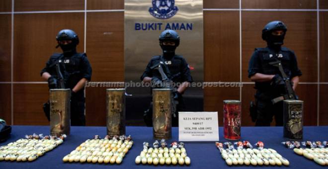 KAWALAN KETAT: Anggota Special Tactical Intelligence Narcotics Group (STING) mengawal ketat dadah disyaki jenis kokain yang dipamerkan pada sidang media oleh Jabatan Siasatan Jenayah Narkotik (JSJN) di Ibu Pejabat Polis Bukit Aman dekat Kuala Lumpur, semalam. — Gambar Bernama