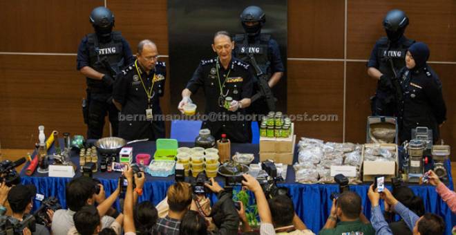 SIDANG MEDIA: Kang (tengah) menunjukkan produk seperti madu, kek, minyak dan marjerin dengan campuran ganja pada sidang media di Ibu Pejabat Polis Bukit Aman, Kuala Lumpur semalam. — Gambar Bernama