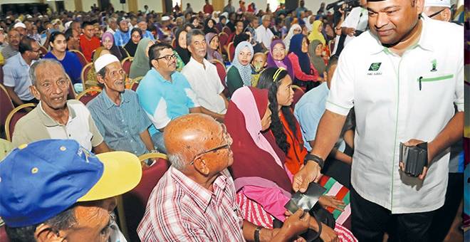 SUMBANGAN: Abdul Azeez (kanan) menyampaikan sumbangan kepada penduduk kawasan Parlimen Balik Pulau pada Program Ziarah Kasih Ramadan 2017 di Dewan Utama Politeknik Balik Pulau, semalam. — Gambar Bernama