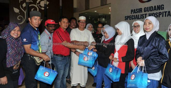 JUADAH SAHUR: Mohamad Fauzi (empat kiri) menyerahkan juadah sahur kepada Mohd Azhar pada Program Singgah Sahur                    Kelab Media Johor (KMJ) 2017 di Hospital Pakar Pasir Gudang di Johor Bahru semalam. — Gambar Bernama