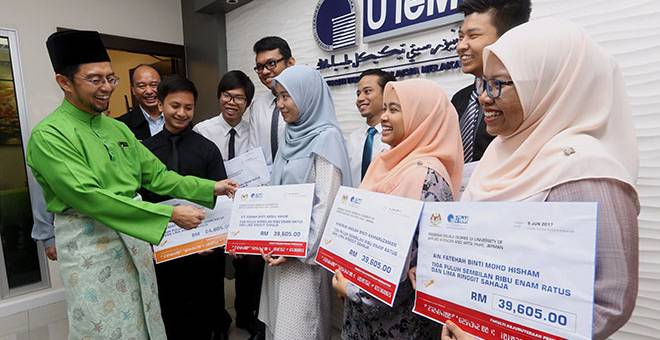 IKUTI PROGRAM: Shahrin (kiri)  menyatakan sesuatu mengenai mock cek dengan pelajar yang bakal mengikuti program Ijazah Berkembar dan program Mobility Outbound di University Of Applied Science and Art (HsH) Jerman di Kampus Induk UTeM Durian Tunggal, Melaka, semalam.  — Gambar Bernama