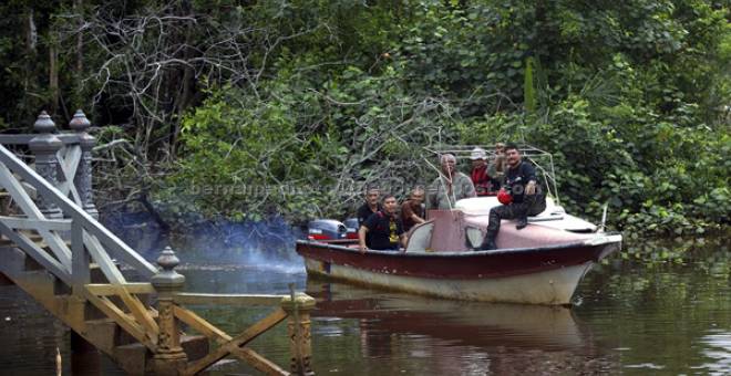 OPERASI PENCARIAN: Anggota polis bersama penduduk kampung menggunakan bot menyusuri sungai hutan paya untuk mencari pesawat Hawk 108 TUDM yang masih belum ditemui selepas dipercayai terhempas di sekitar Kampung Ibok, semalam. — Gambar Bernama