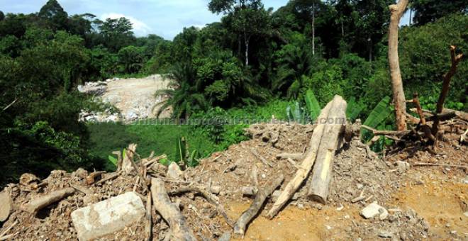 BUKAN TEMPAT BUANG SAMPAH: Timbunan kayu dan sisa pembinaan yang didakwa penduduk dilonggokkan oleh kontraktor di Kampung Melayu FRIM di Kepong semalam. — Gambar Bernama