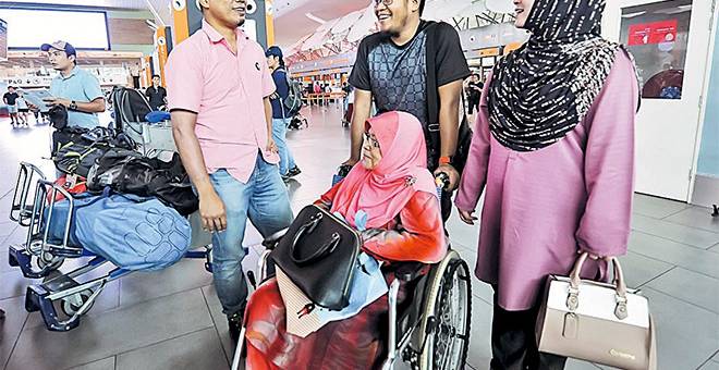 BERI SOKONGAN: Mohd Khafiz (kiri) bercakap dengan Roslida Abdullah, 42, isteri Ramli Abdul Majid, 44, yang hilang ketika mendaki Gunung Damavand, Iran sebelum berlepas di Lapangan Terbang Antarabangsa Kuala Lumpur 2 (KLIA2) dekat Sepang, semalam. Turut hadir memberi sokongan Zaharah Salleh (kerusi roda) ibu Allahyarham Syed Redzuan Syed Salim Shatri, dan Syed Shafwan (dua kanan). — Gambar Bernama