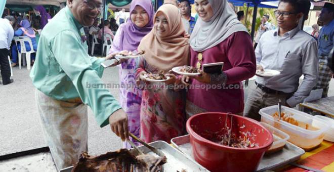 RAIKAN TETAMU:  Mohd Fauzi (kiri) meraikan tetamu pada Majlis Jalinan Mesra Aidilfitri di Pejabat SPRM di Jalan Sultan Badlishah, Alor Setar, semalam.  — Gambar Bernama