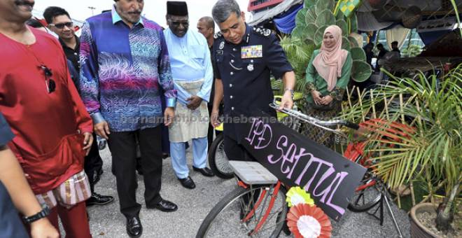 TERTARIK: Khalid melihat basikal klasik zaman Jepun yang digunakan sebagai hiasan pada Majlis Sambutan Hari Raya Aidilfitri Polis KL di Ibu Pejabat Polis Kontinjen (IPK) dekat Kuala Lumpur, semalam. Turut kelihatan Ketua Polis Kuala Lumpur Datuk Amar Singh Ishar Singh (dua kiri). — Gambar Bernama